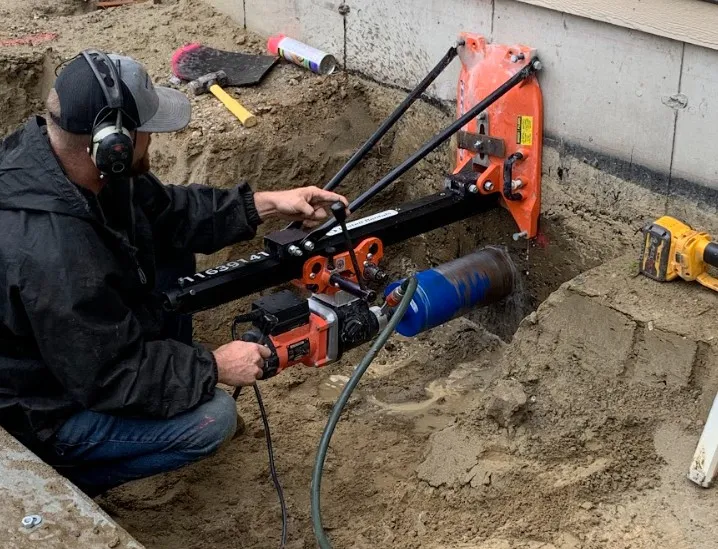 Coring through an existing foundation wall for a septic tie-in
